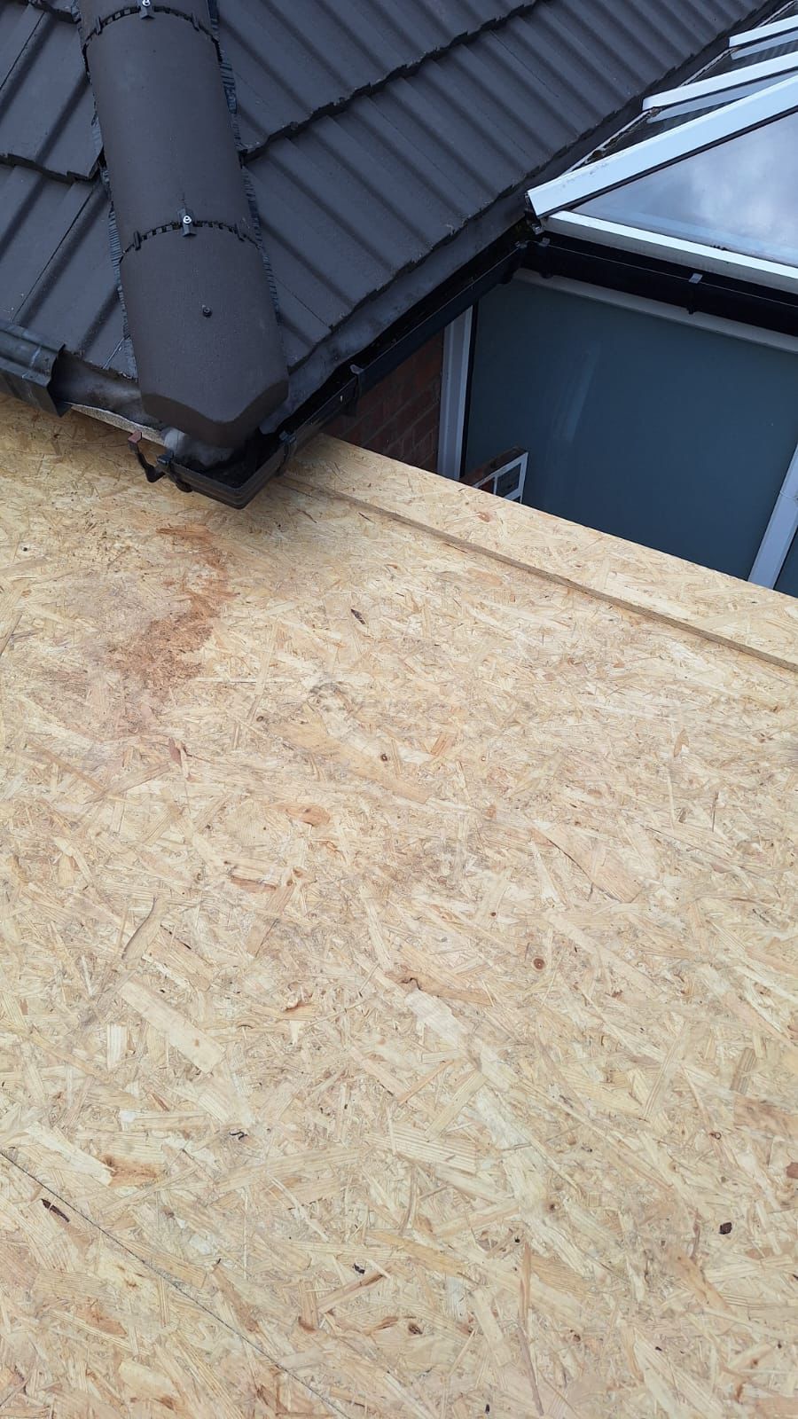 A close up of a roof with a wooden plank on it.