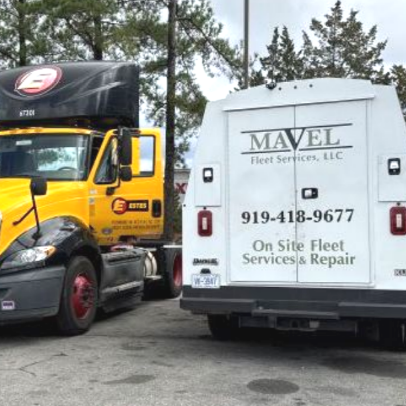 Yellow and black semi-truck with a white service truck parked outdoors in Cary, NC. 