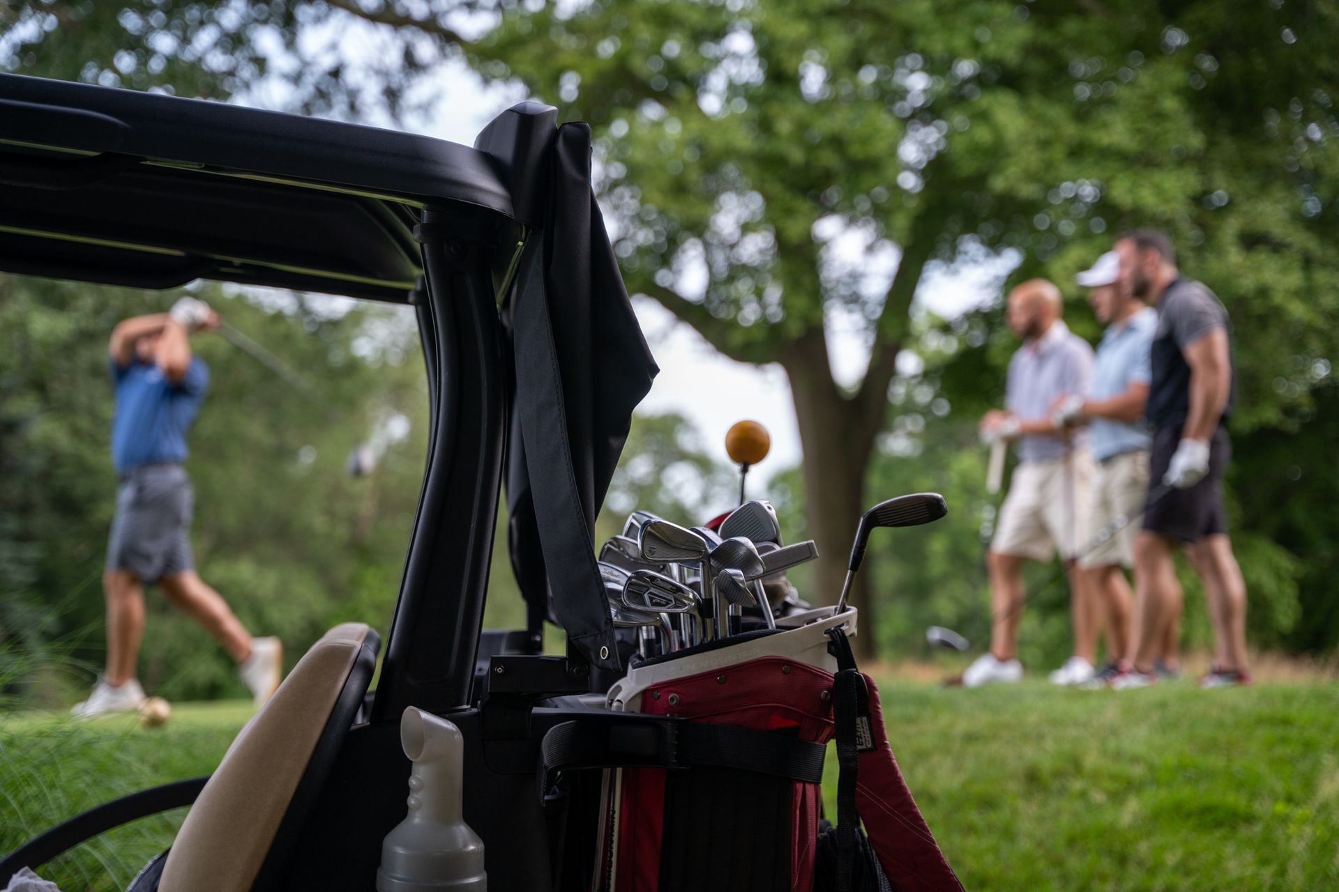 A group of men are playing golf on a golf course.