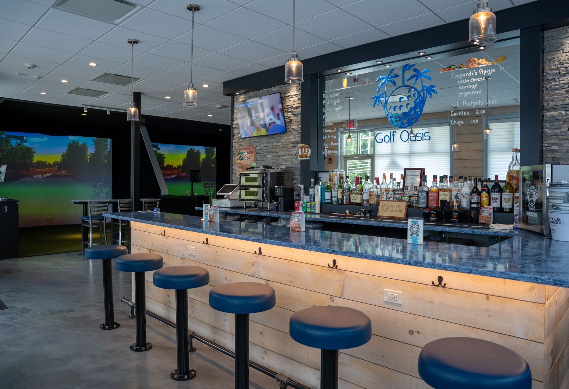 A bar with stools and bottles of liquor on it in a restaurant.