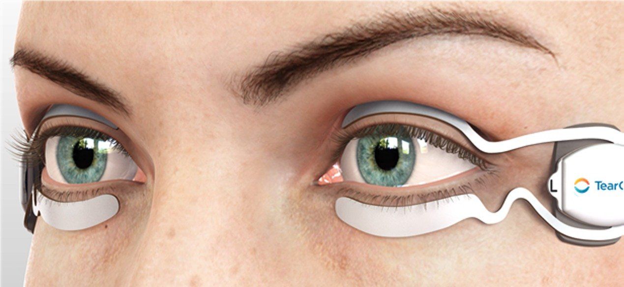 A close up of a woman 's eyes with tear care device in use