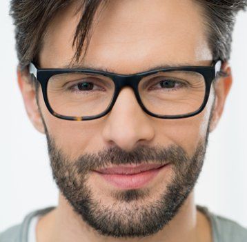 A man with a beard and glasses is smiling for the camera.