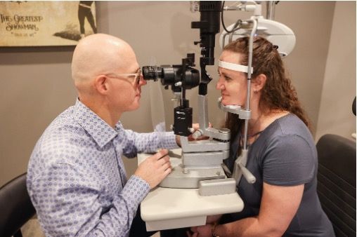 A woman is getting her eyes examined by Dr. Lyons