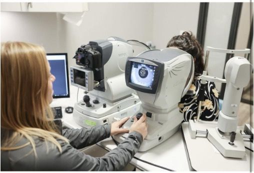 A woman is using a machine to check a person 's vision.