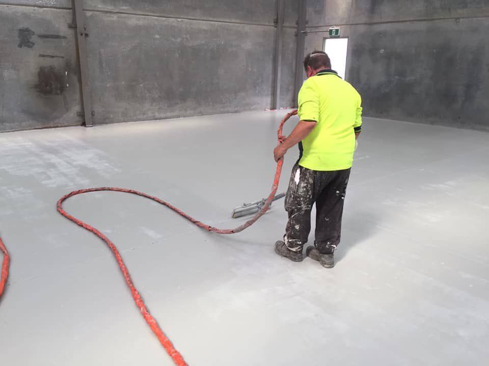 Worker Brushing Floors — Epoxy Floor Coating in Mackay, QLD