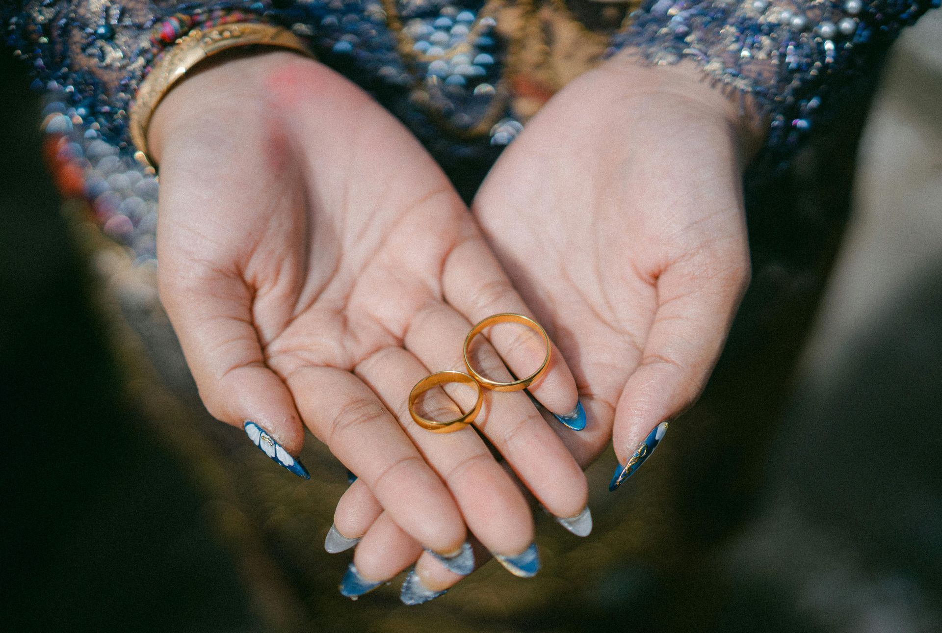 Lady's hands holding wedding bands