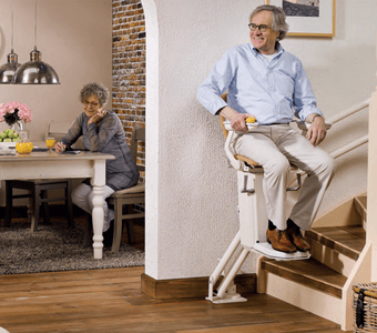 A man sitting of stair lift