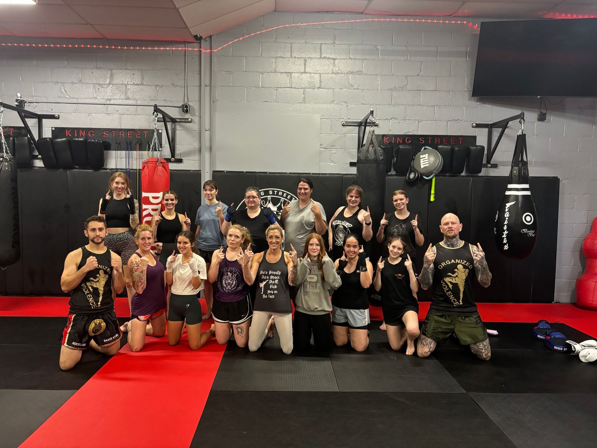 A group of people are posing for a picture in a gym.