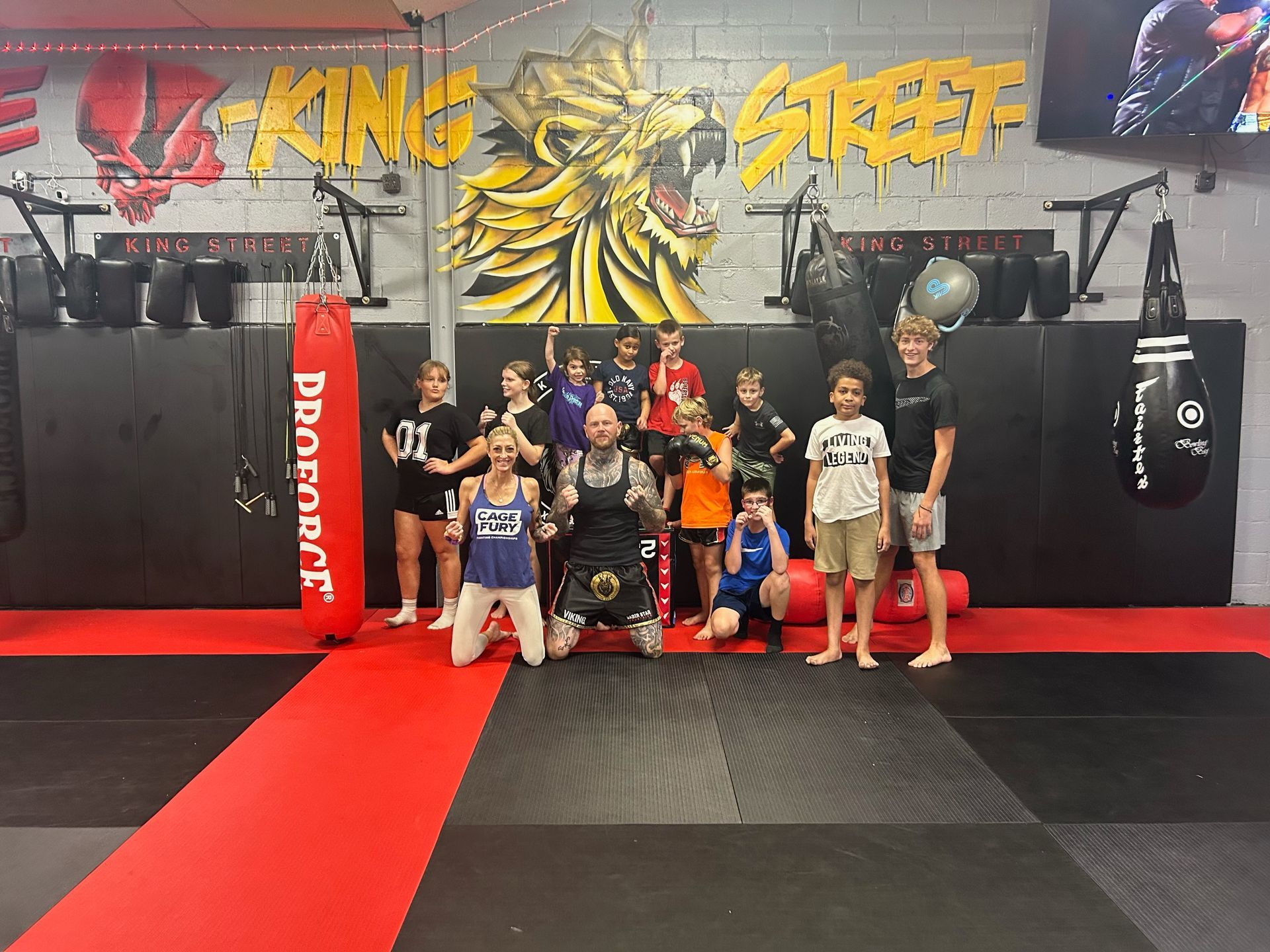 A group of people are posing for a picture in a gym.