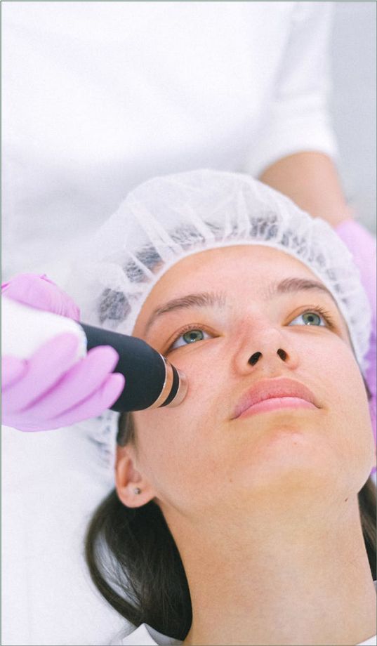 A woman is getting a facial analysis at a medspa.