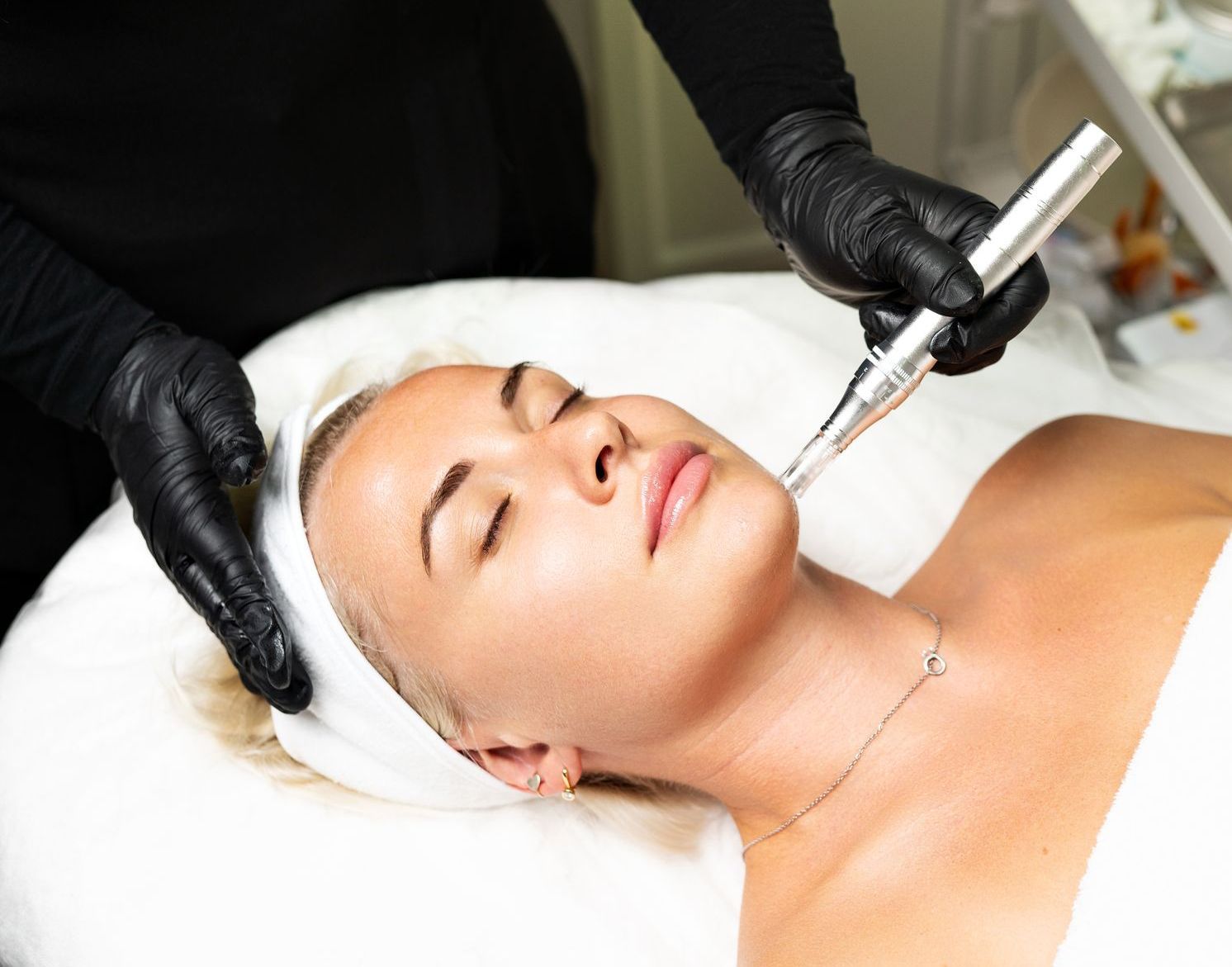 A woman is laying on a bed getting a facial treatment.