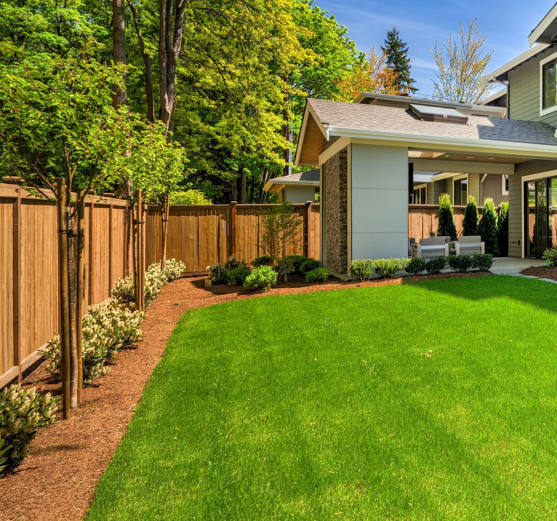 A house with a large lawn and a wooden fence