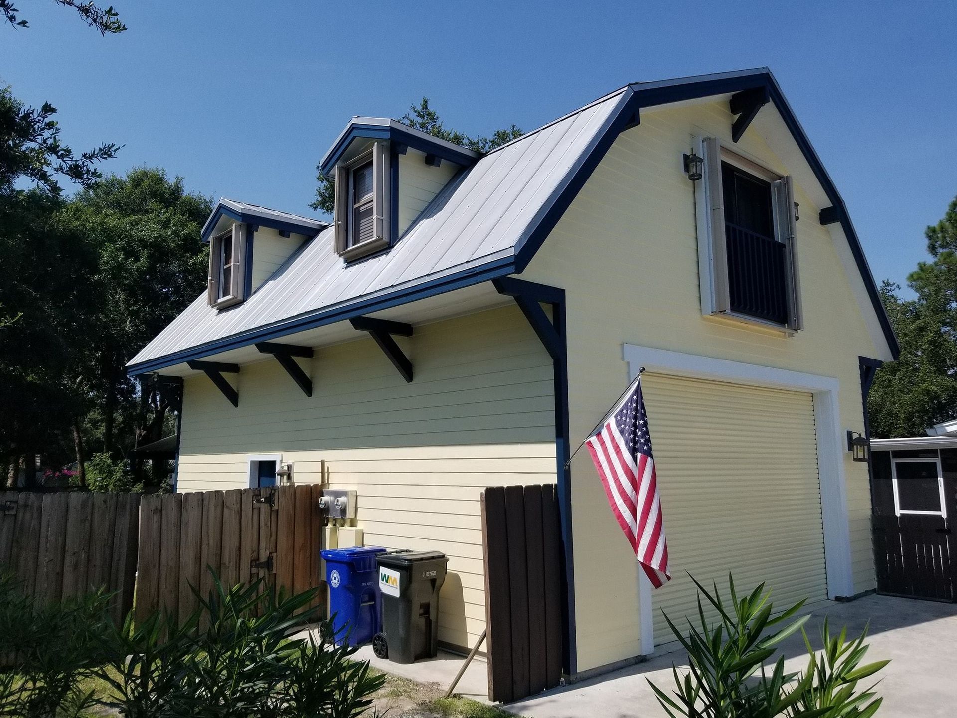 A yellow garage with an american flag in front of it