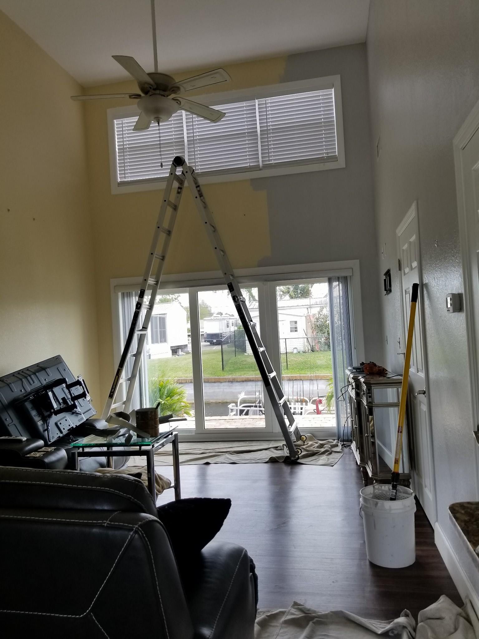A living room with a ladder in the middle of it