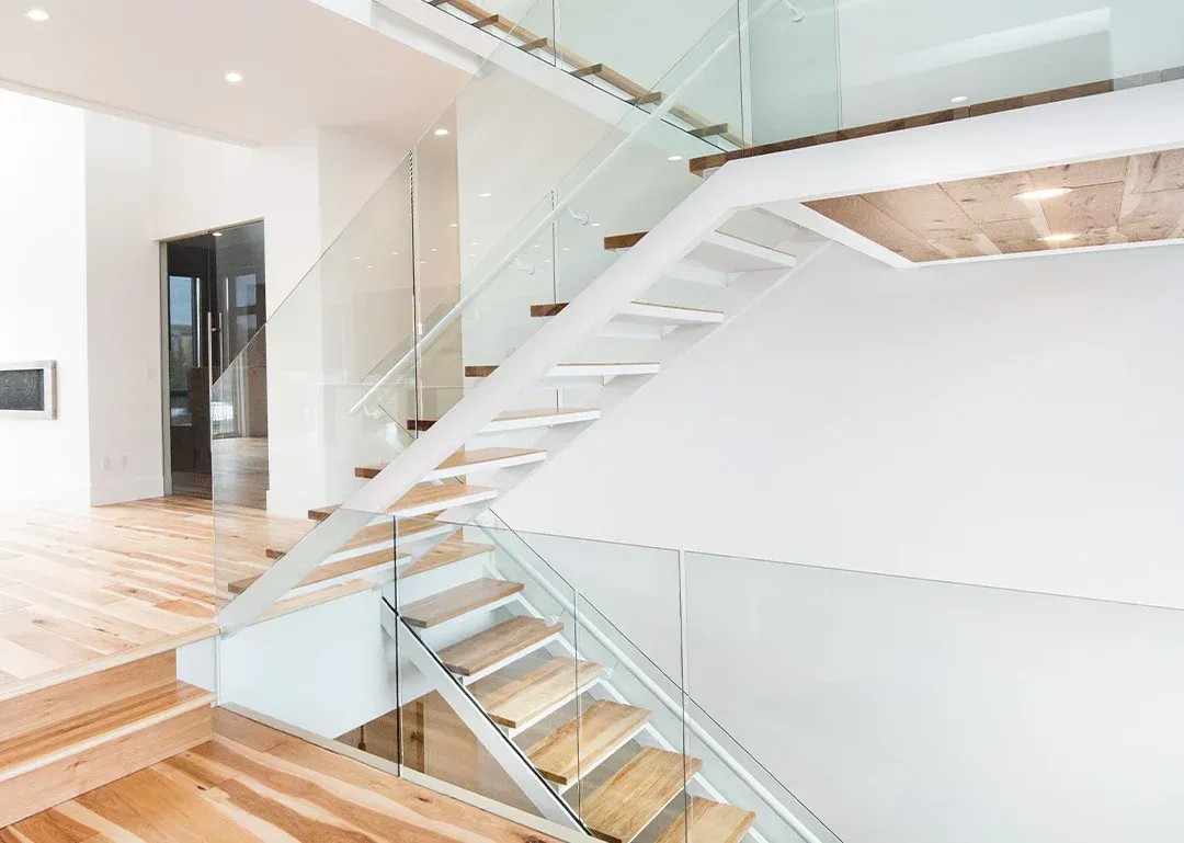 A modern staircase with wooden steps and a glass railing.