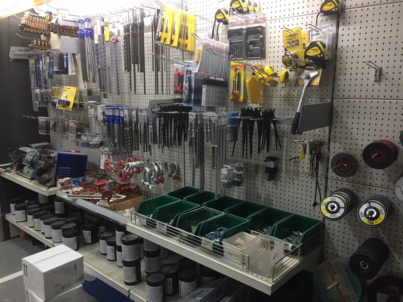 Attrezzi da ferramenta esposti su pannelli forati e scaffali.