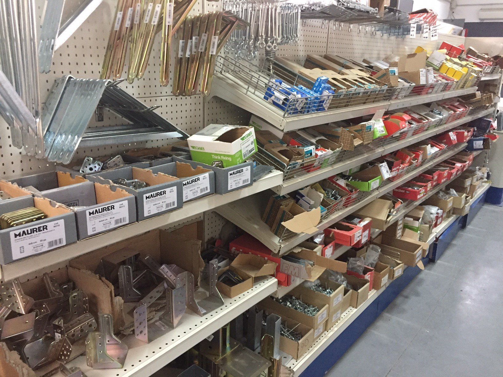Scaffali di ferramenta pieni di vari elementi di fissaggio e utensili.