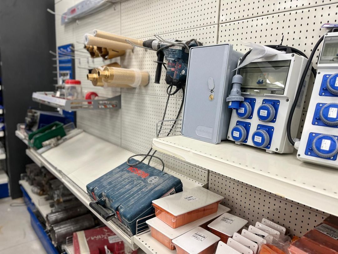 Scaffali di un negozio di ferramenta riforniti di apparecchiature elettriche, utensili elettrici e altre forniture varie.