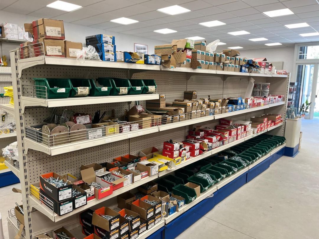 Scaffali di un negozio di ferramenta pieni di vari materiali, tra cui scatole e contenitori.