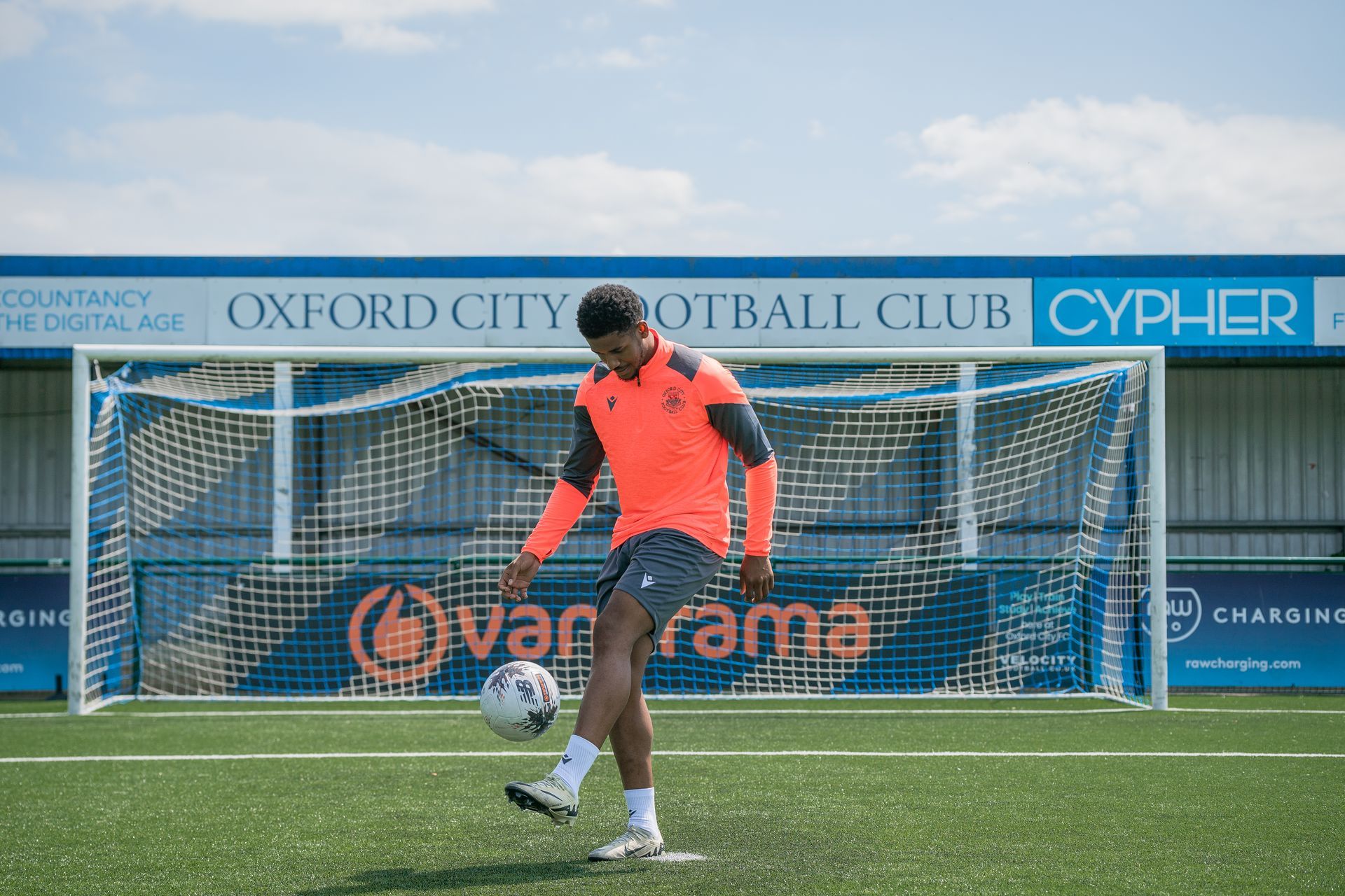 Corie Andrews does kick-ups in front of Oxford City FC stand