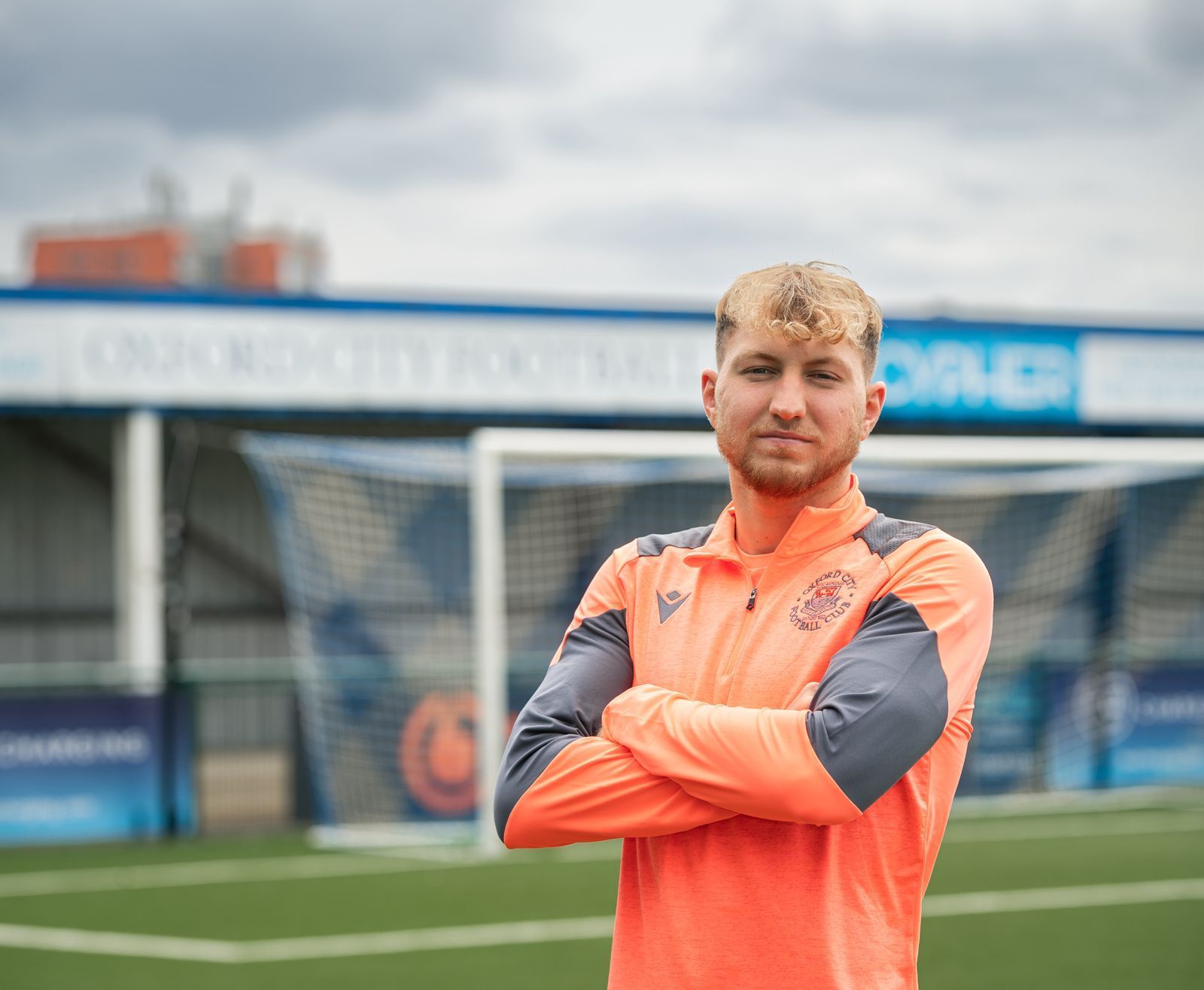 Jacob Roddy with arms folded in front of stand.