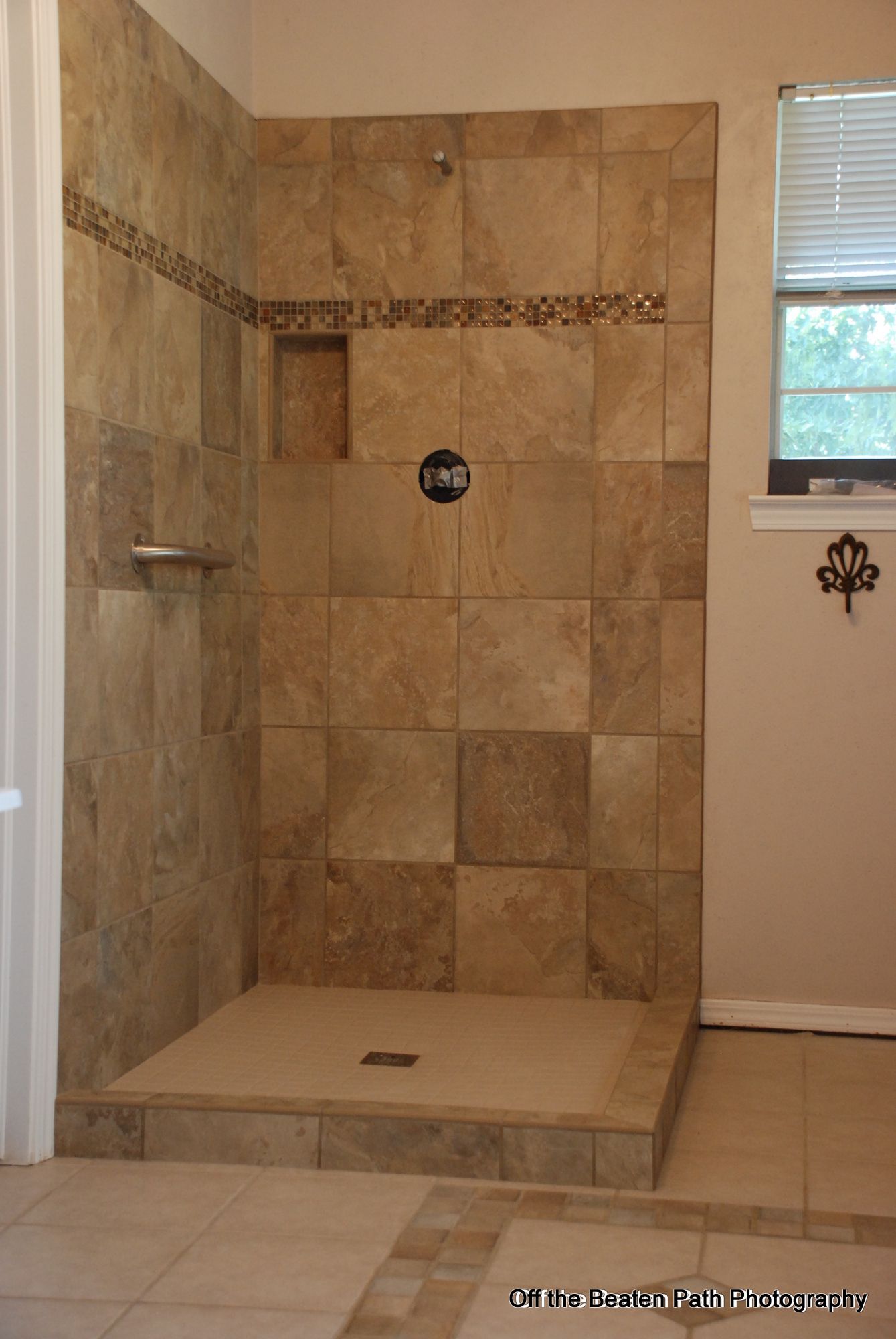 A bathroom with a walk in shower and a window