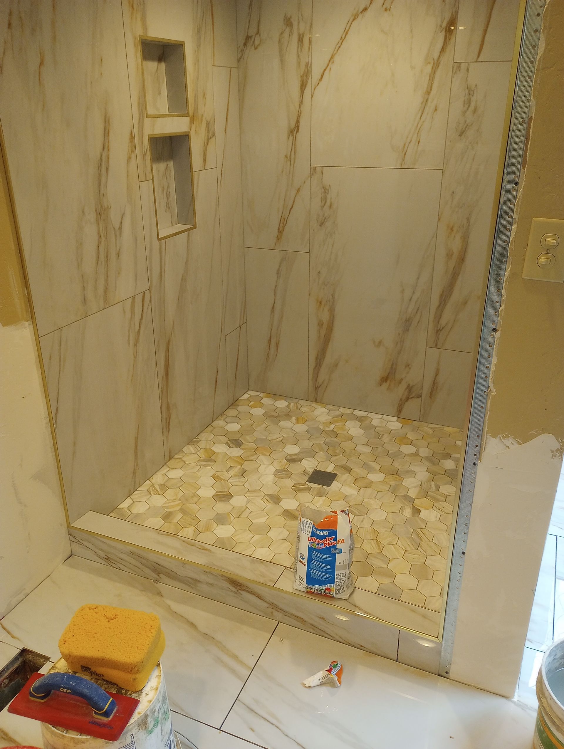A shower stall is being remodeled in a bathroom.