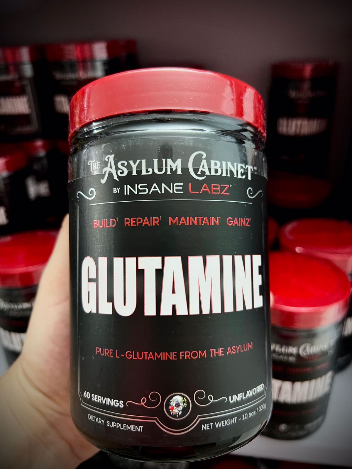 Frasco de suplementos negro y rojo con la etiqueta 