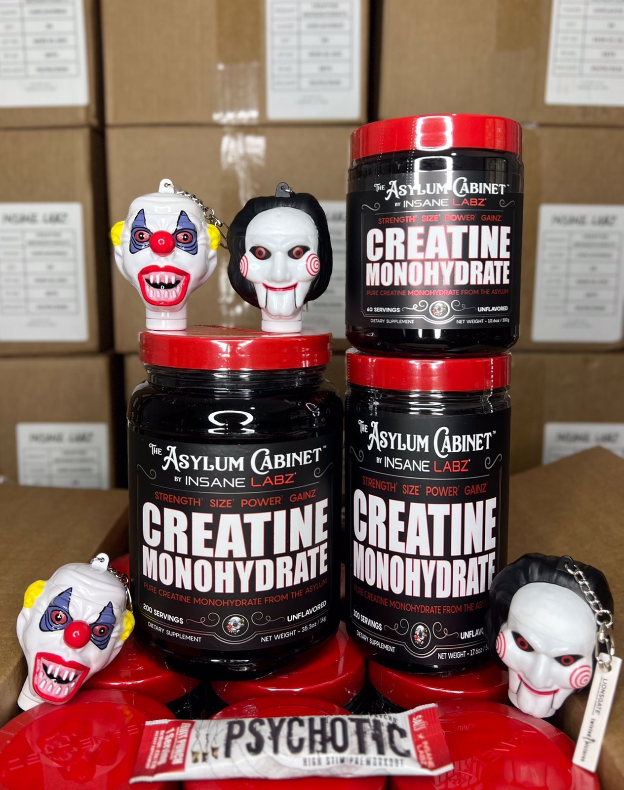 Frascos surtidos de suplementos Asylum Cabinet con figuras de payasos terroríficos y enmascarados en la parte frontal; empaque rojo y negro.