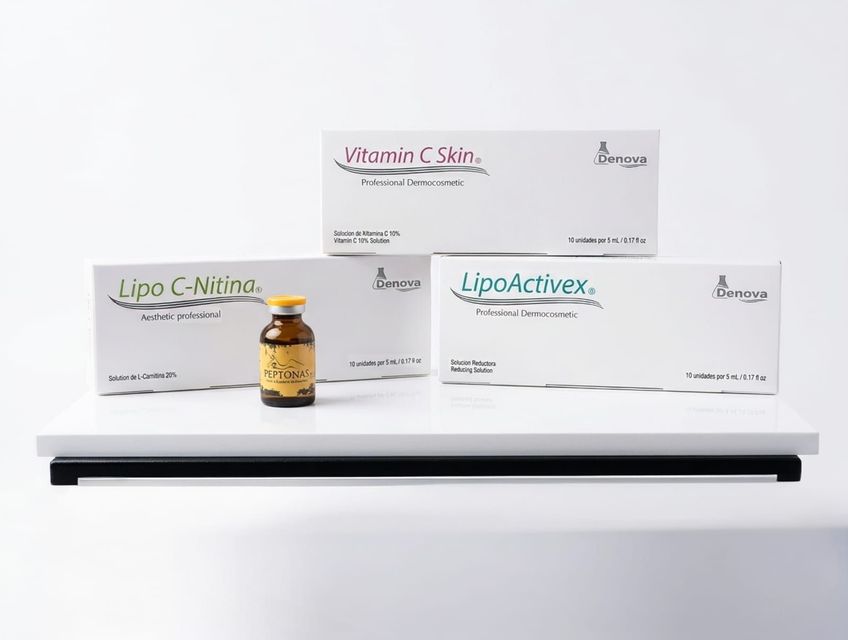 Tres cajas de productos cosméticos y un pequeño frasco ámbar sobre un estante blanco con fondo blanco.