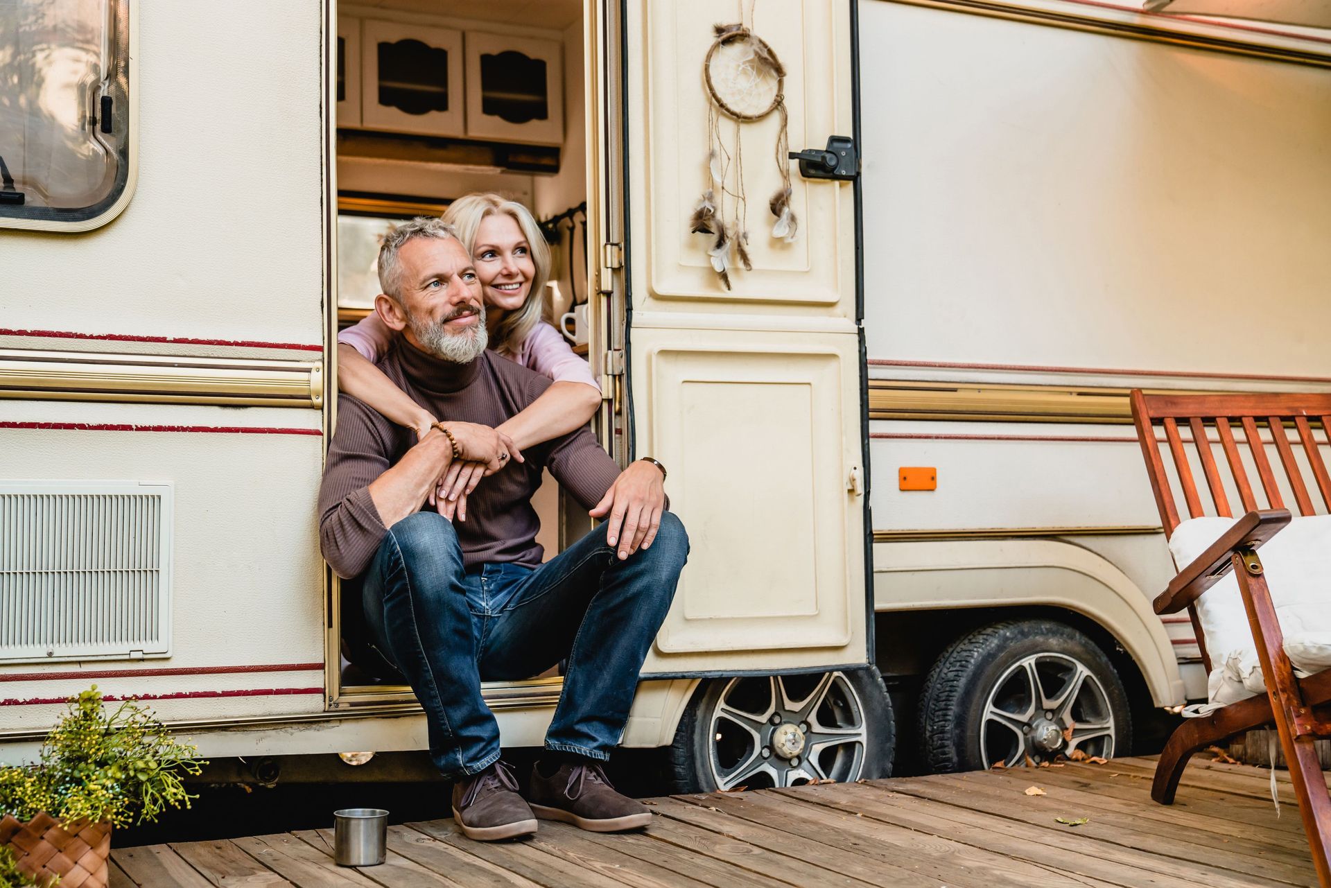 aged happy couple sitting van doorway