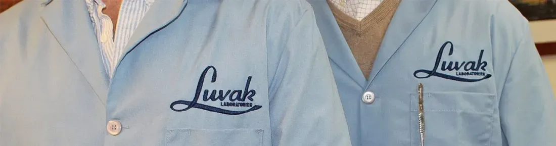 Two people wearing light blue lab coats with the name 