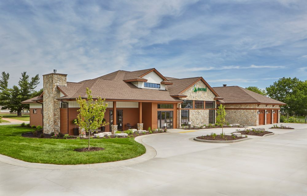 A large house with a lot of windows and a driveway in front of it.