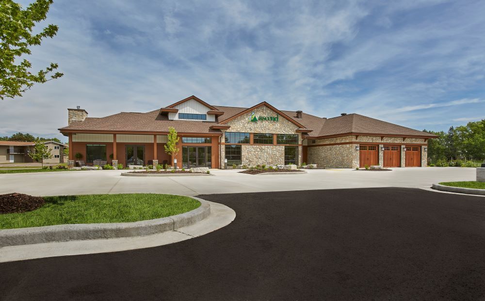 A large house with a parking lot in front of it.