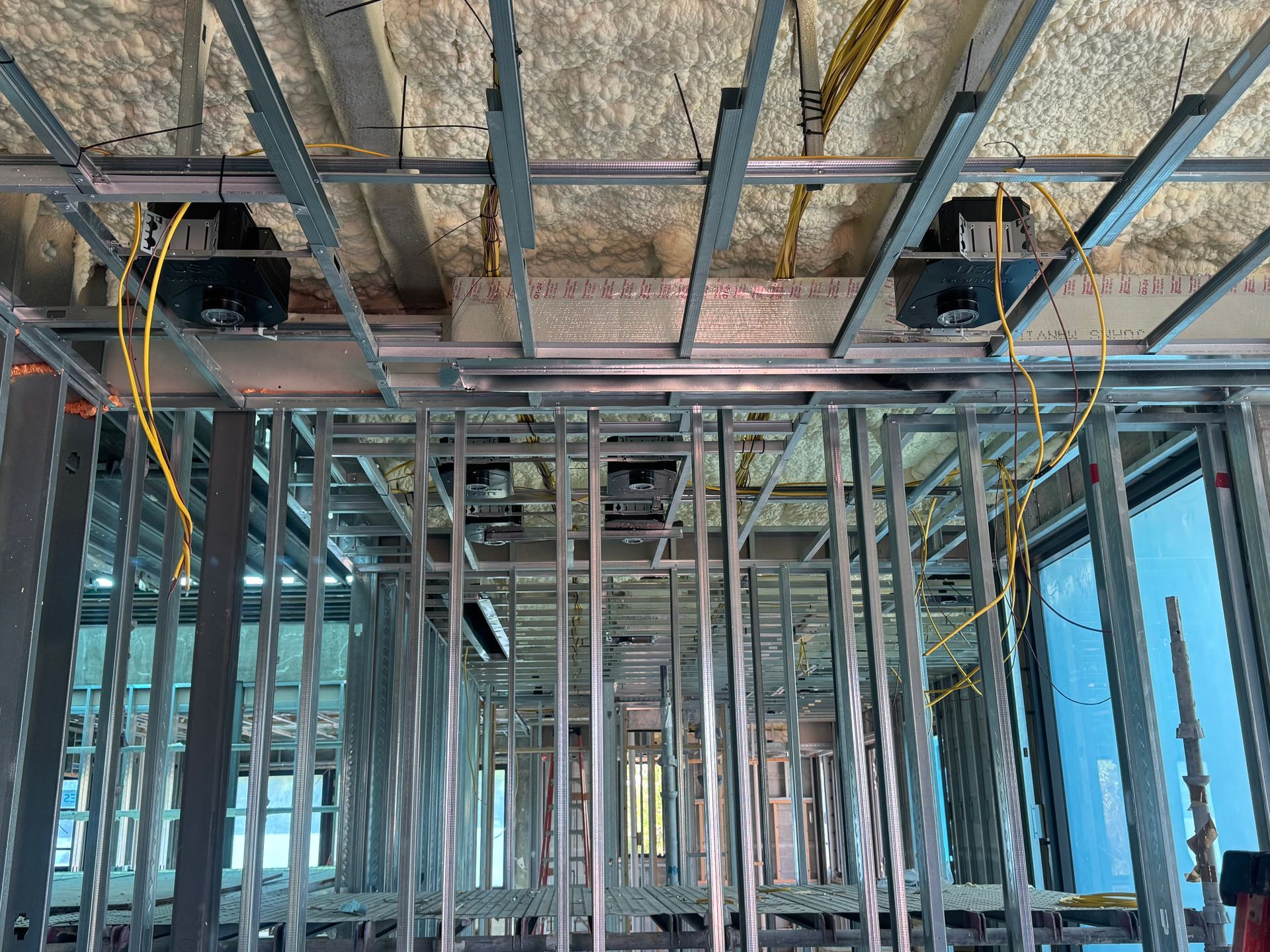 Metal framing of a building interior. HVAC units are installed in the ceiling.