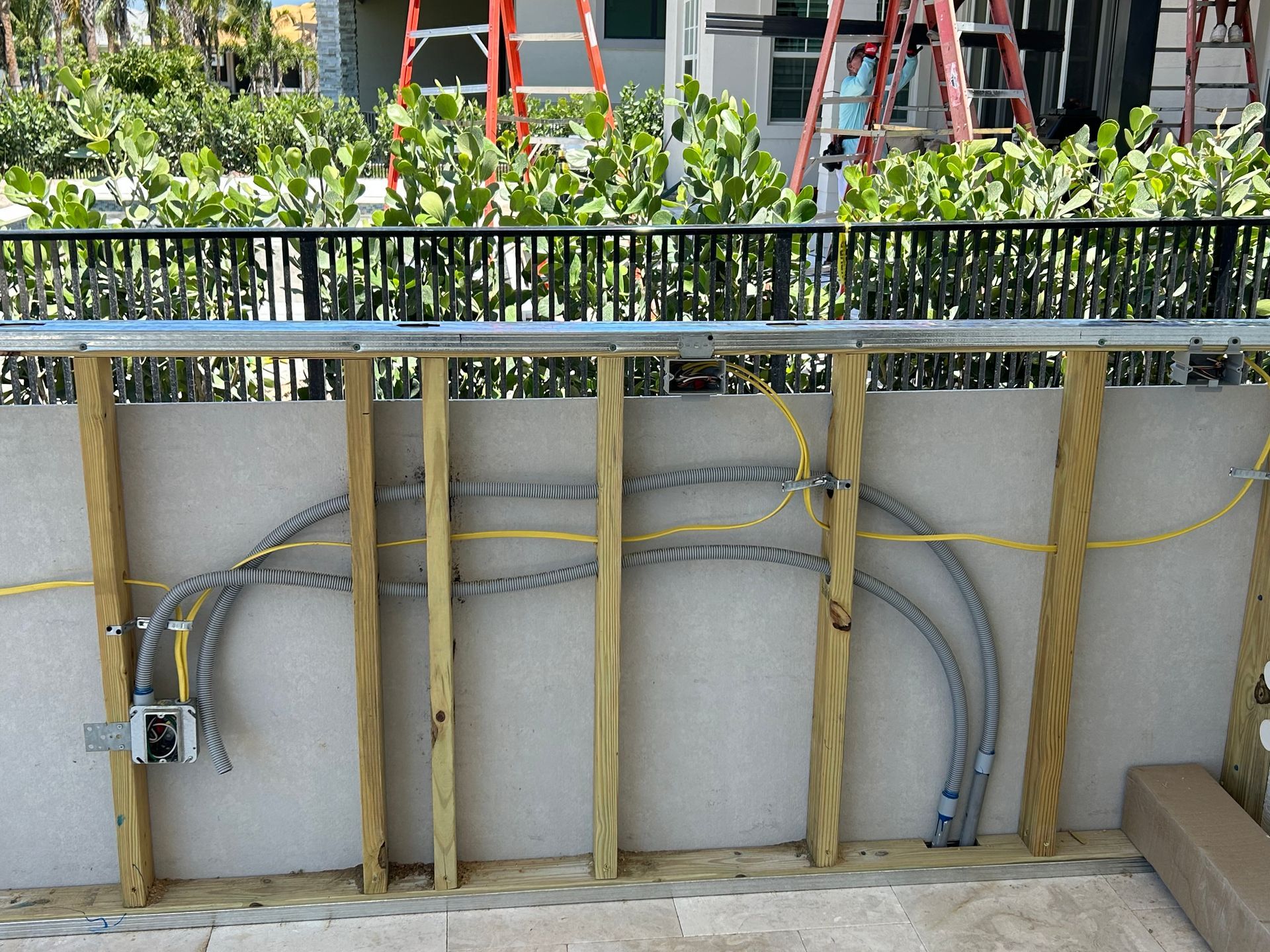 Electrical wiring installation on a wall with conduit and wooden supports.