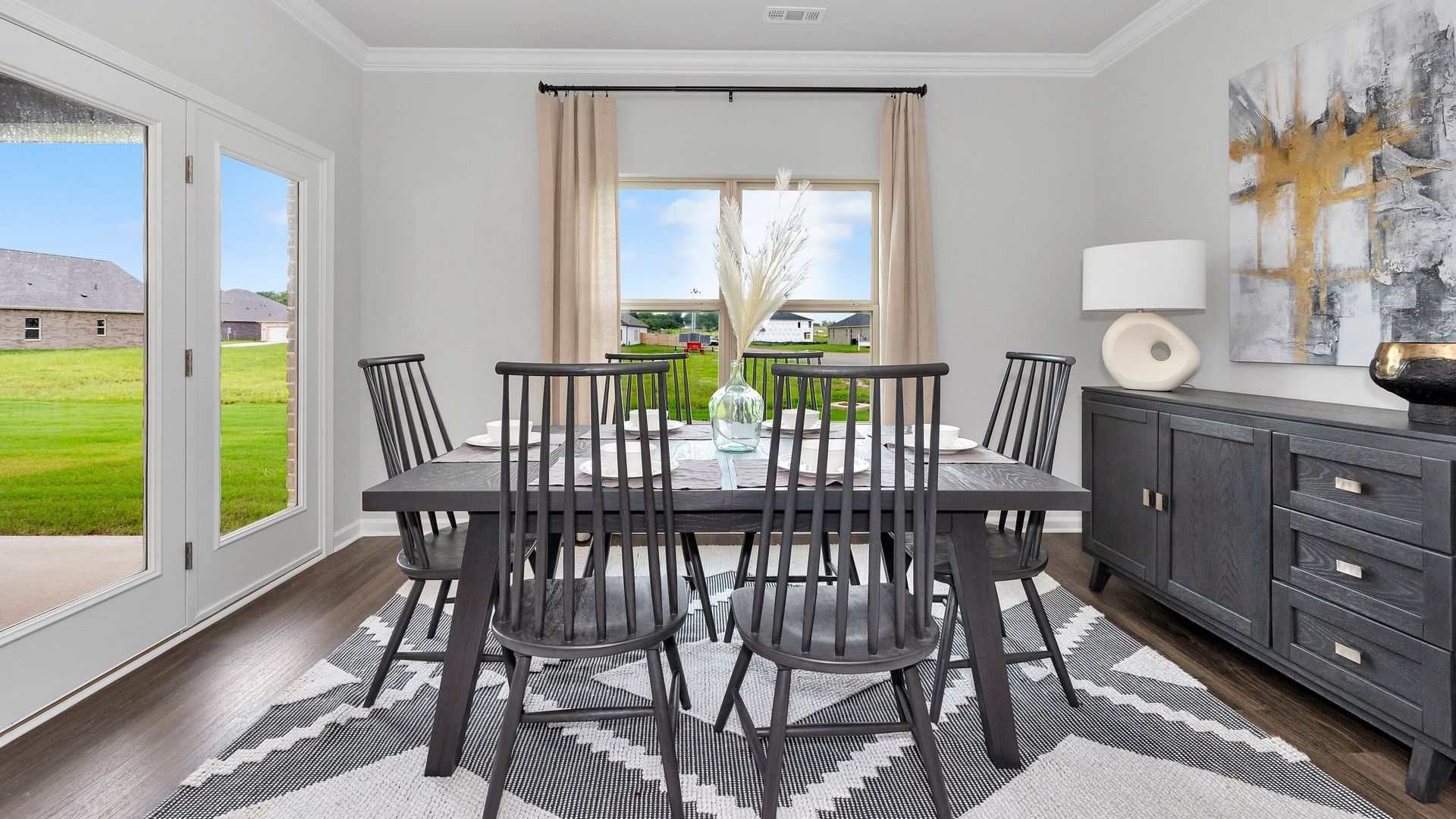 Dining room with a dark wood table, chairs, and a decorative sideboard.