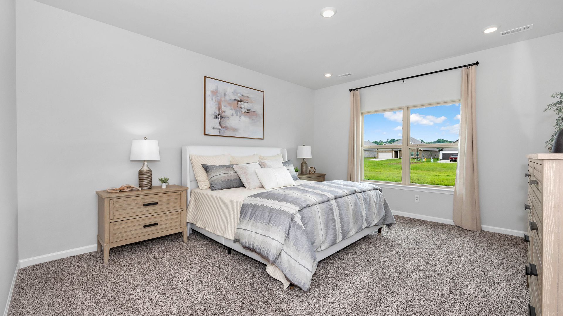 Bedroom with a bed, dressers, window, and neutral color scheme.
