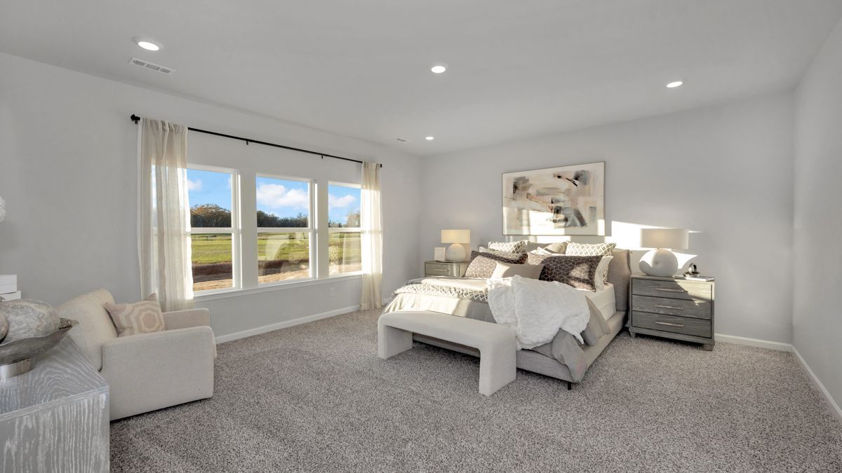 Bedroom with large window, gray walls, and neutral-toned furniture.