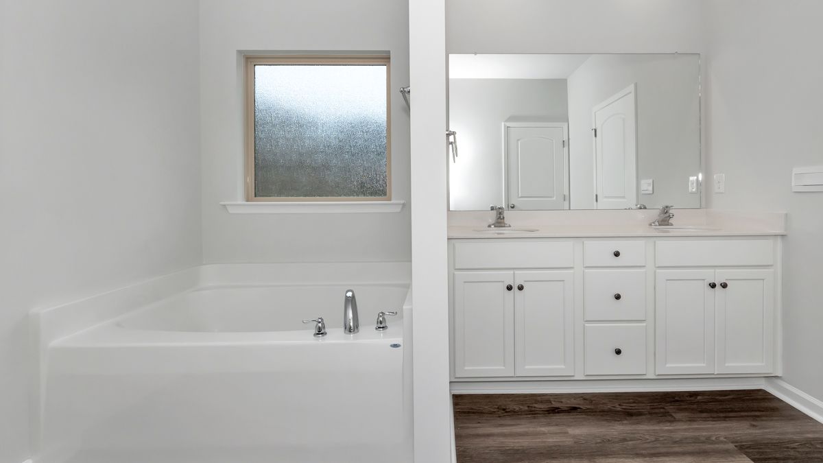 White bathroom with tub and double sink vanity.