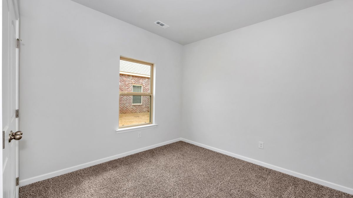 Empty room with white walls, brown carpet, and a window.