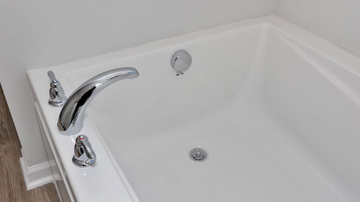 White bathtub with chrome faucet and fixtures.