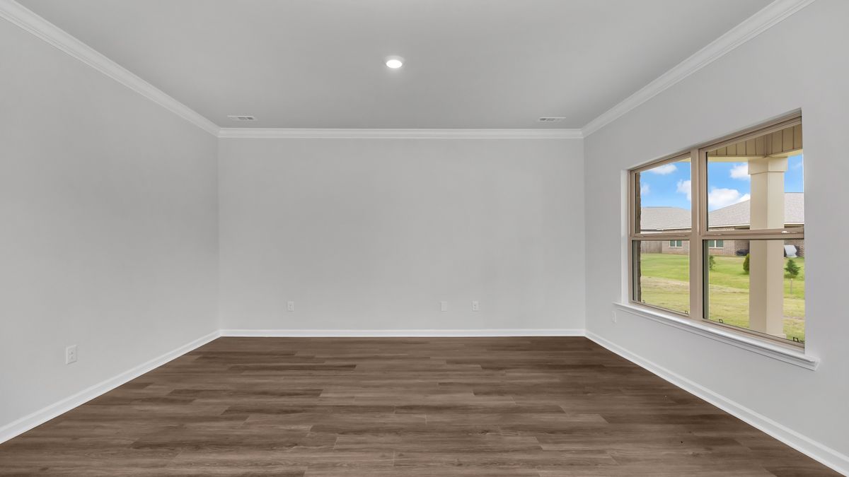 Empty room with wood floor, white walls, a window, and view of outdoors.