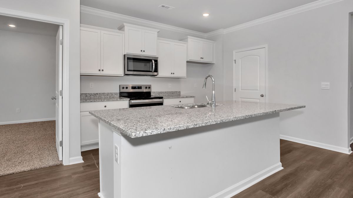 Kitchen with white cabinets, granite countertops, and an island.