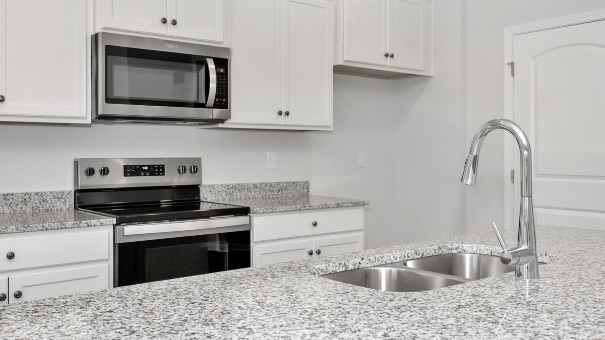 Kitchen with white cabinets, stainless steel appliances, and granite countertops.