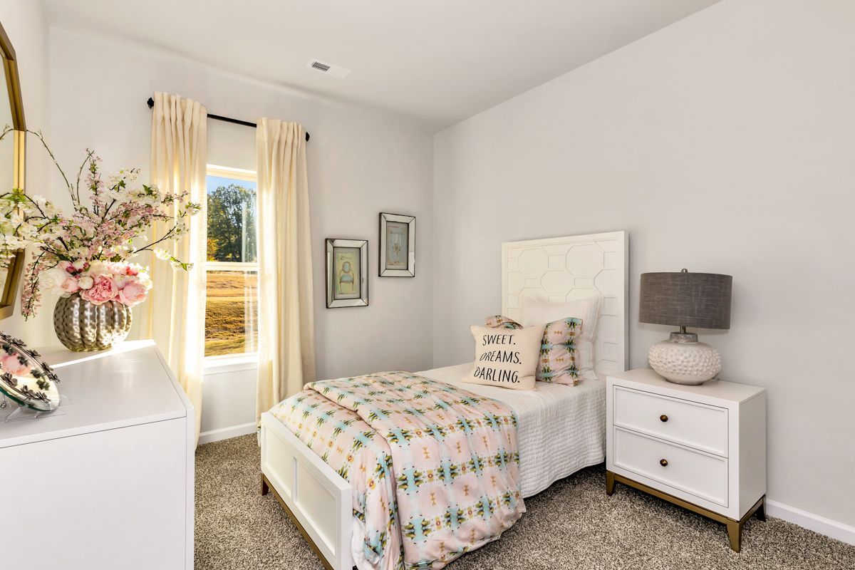Bedroom with a single bed, nightstand, dresser, window with curtains, and floral decor.