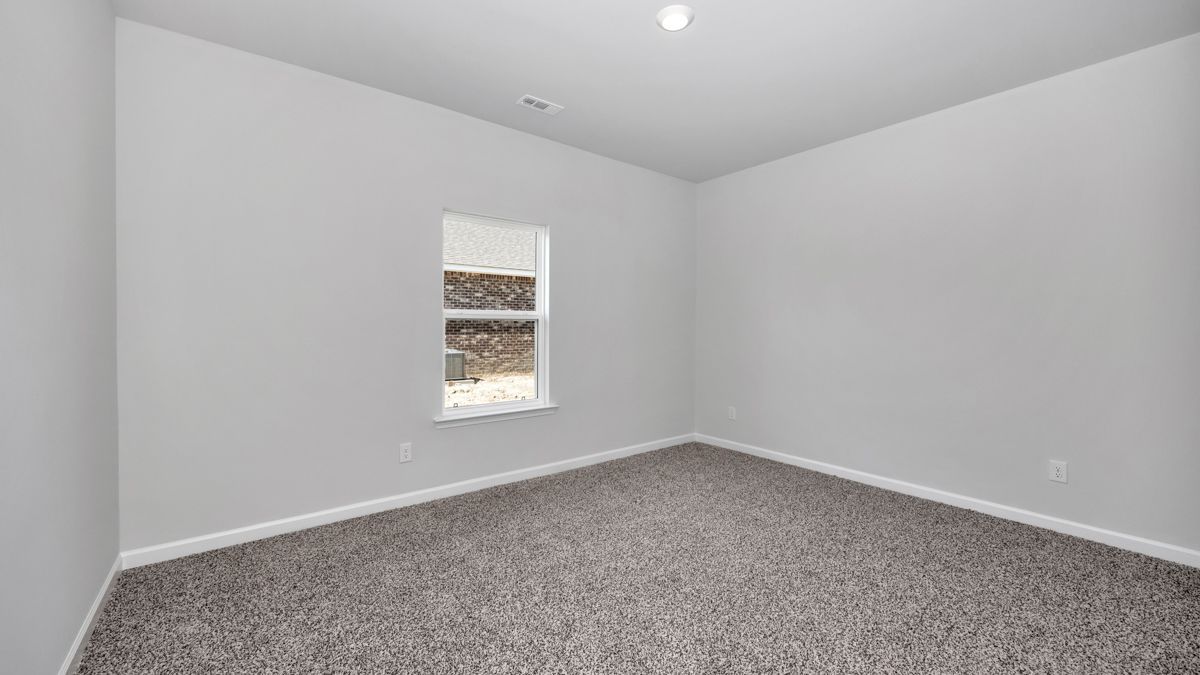 Empty room with gray walls, carpet, and window.