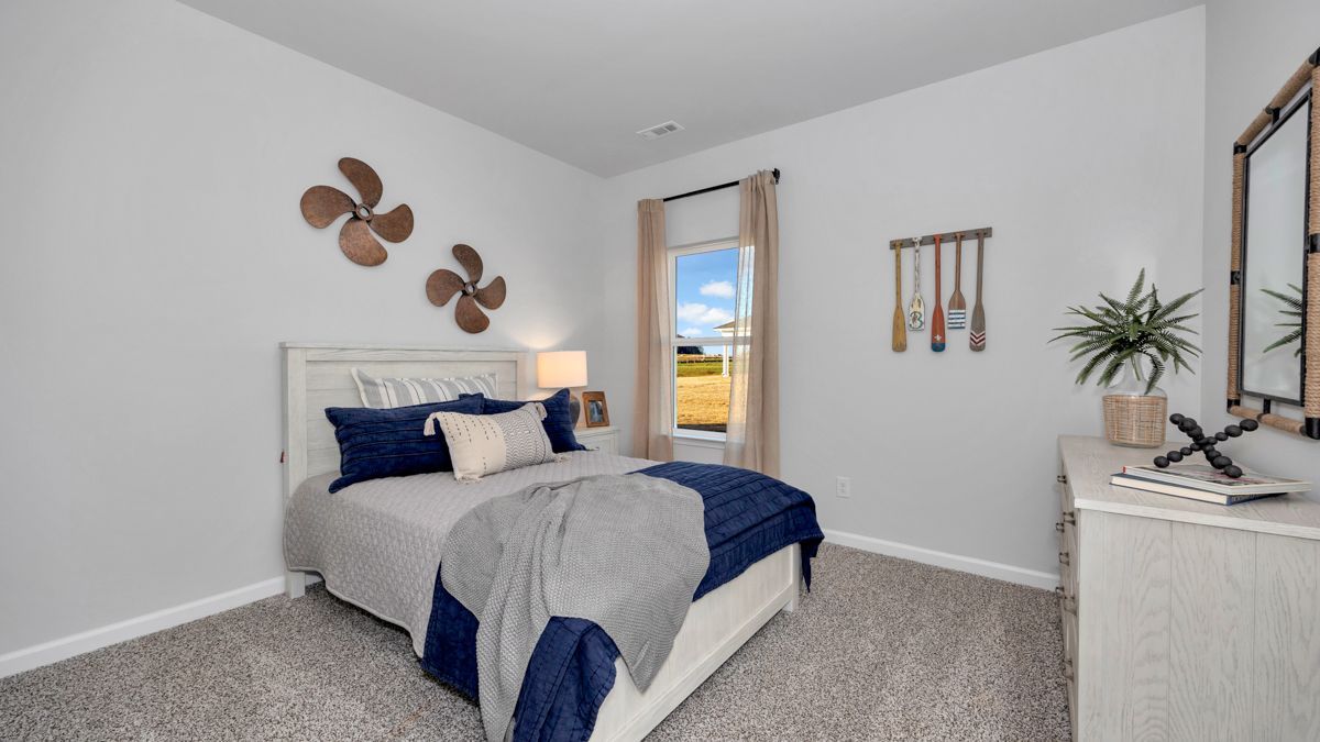Bedroom with nautical decor: bed, gray walls, window, propellers, oars, and a dresser.