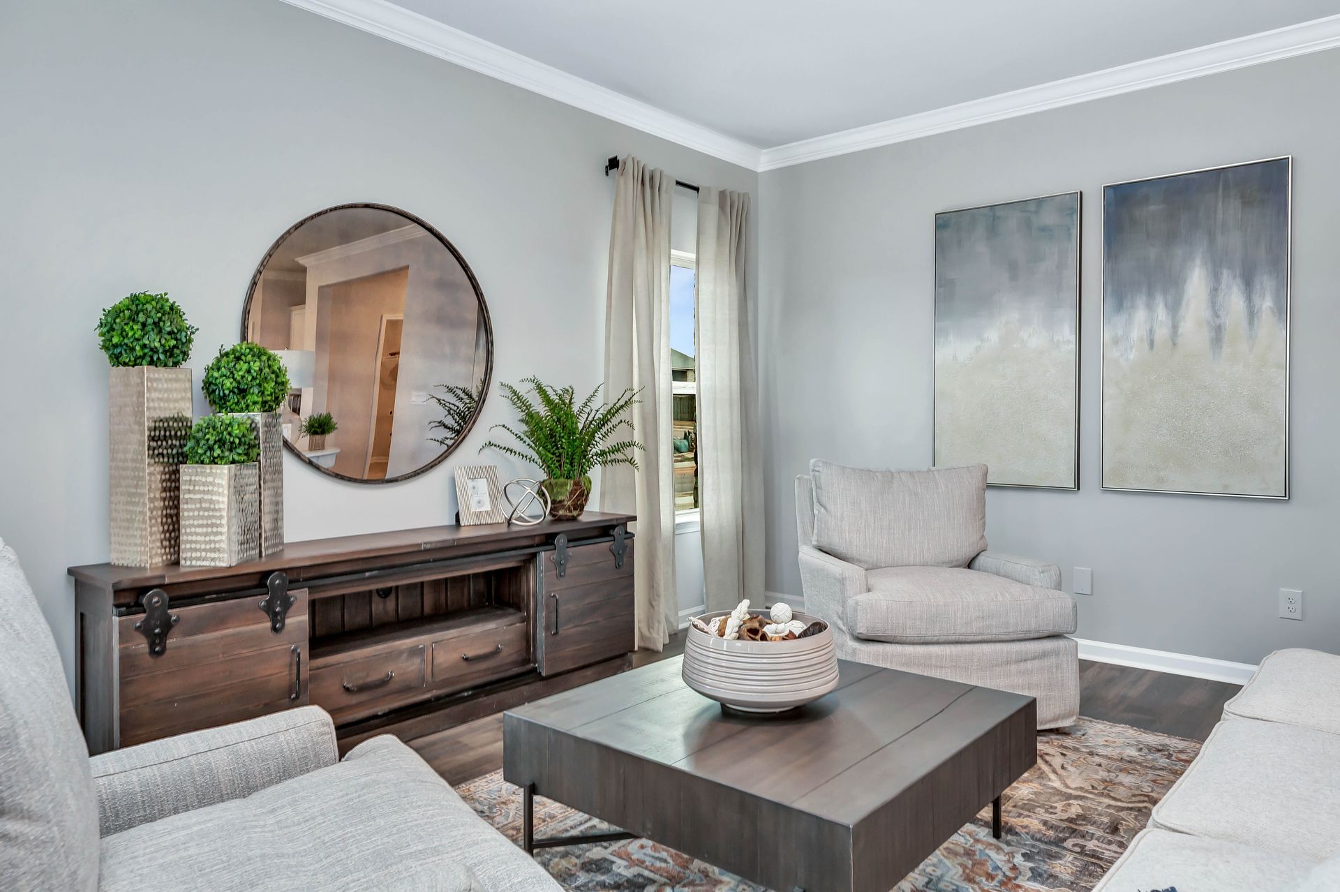 Living room with gray walls, furniture, and decorative items, including a mirror and artwork.
