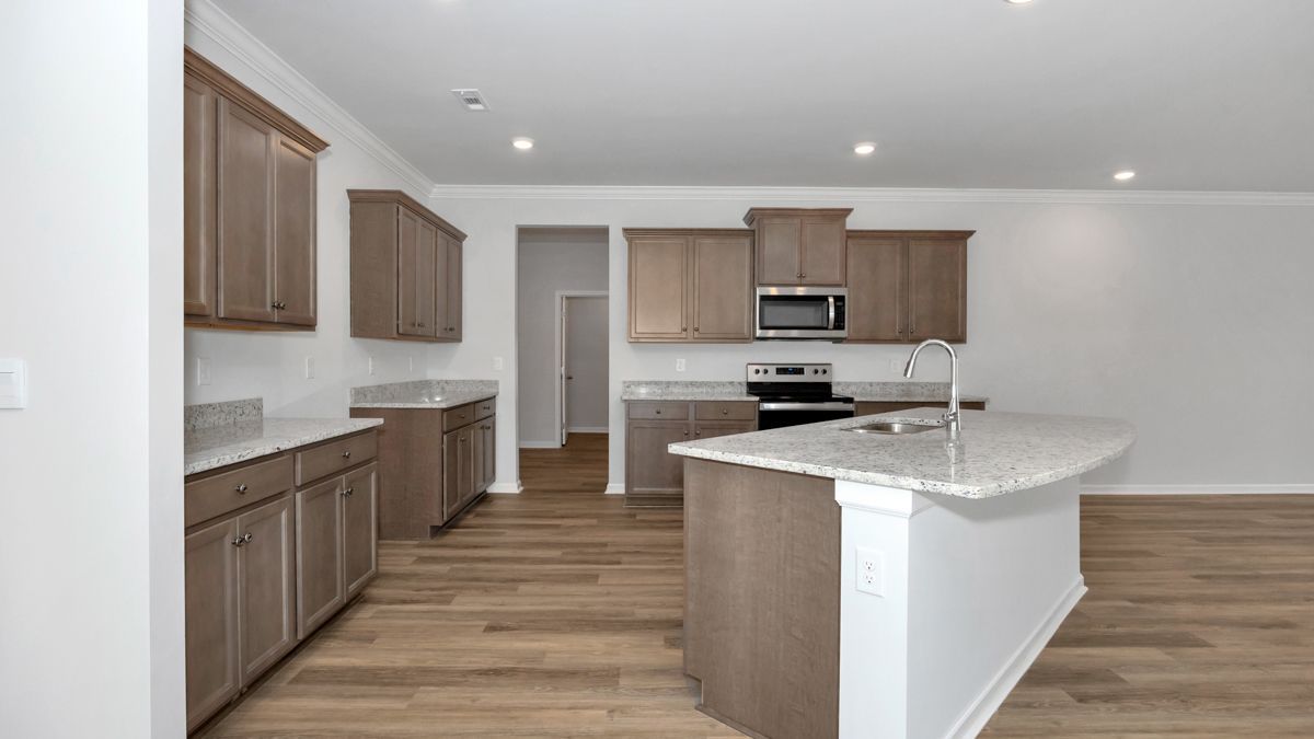 Kitchen with light-colored wooden cabinets, granite countertops, island, and hardwood floors.